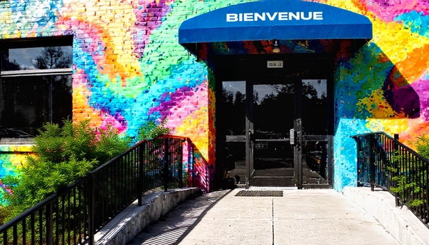 Rampe d'accès menant à un bâtiment coloré, illustrant l'accessibilité et l'inclusion dans le design.